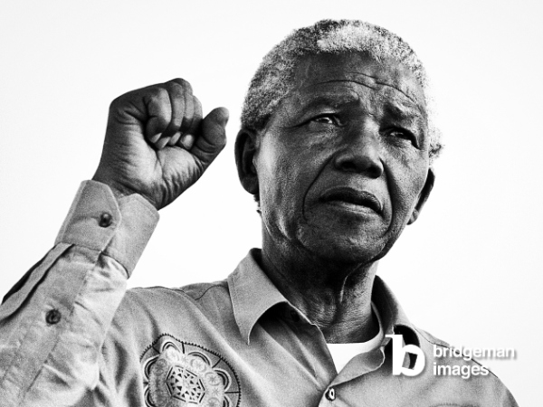 Fotografie in schwarz-weiß von Nelson Mandela der eine Faust hochhält