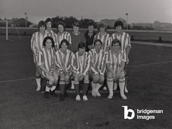A women's football team from 1969 posing in a team photo 