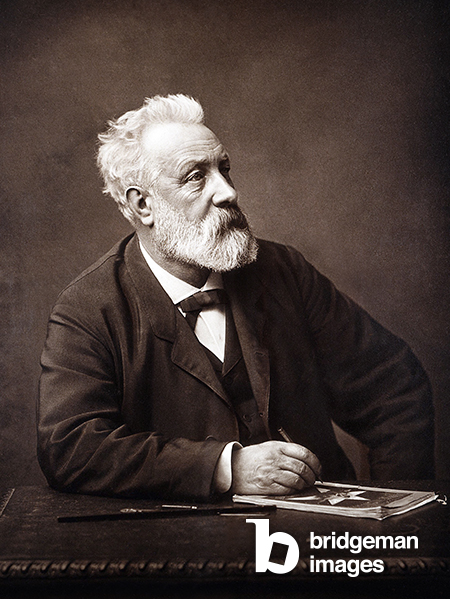 Portrait of the writer Jules Verne in Amiens, seated at his writing desk in 1892, Herbert, Charles (1829-1911) / Private Collection / © Patrice Cartier. All rights reserved 2023 / Bridgeman Images