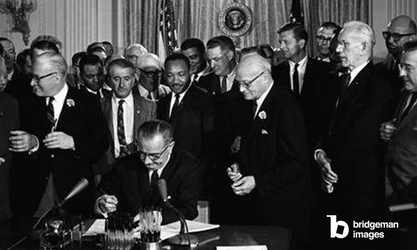 LEGGE SUI DIRITTI CIVILI, 1964 Il Presidente Lyndon B. Johnson firma la legge sui diritti civili del 1964 mentre Martin Luther King, Jr. e altri guardano. Fotografia di Cecil Stoughton, 2 luglio 1964. / Granger / Bridgeman Images
