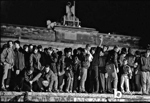 Crowd celebrating the opening of the West Berlin-GDR border at the top of the Berlin Wall, Brandenburg Gate, 10 November 1989 (b/w photo) / Berlin, Germany / © Hans Peter Steibing / Bridgeman Images