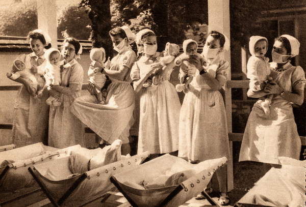 Maskierte Krankenschwestern versorgen Säuglinge im Hospital Saint-Michel, Paris, Frankreich, ca. 1935 (Postkarte) / Privatsammlung / The Burns Archive and Museum of Historical Photography / Bridgeman Images