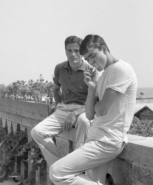 immagine di pasolini seduto su una balaustra a venezia con un amico